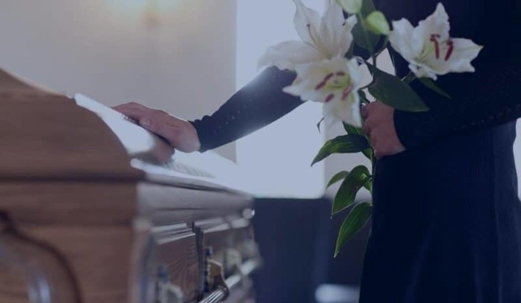 Lady placing hand on coffin