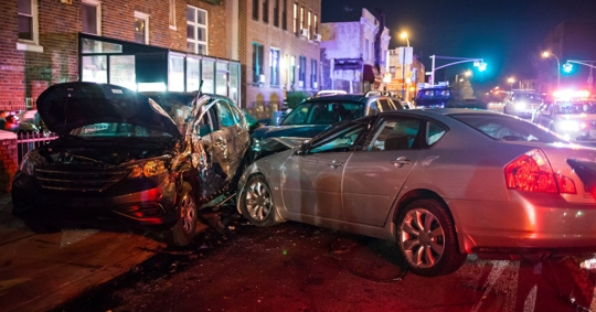 Photo of a car accident at night in an urban area.